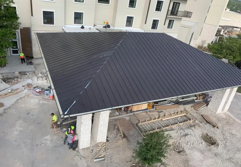 Metal roofing installation team working on a commercial building in Argentine